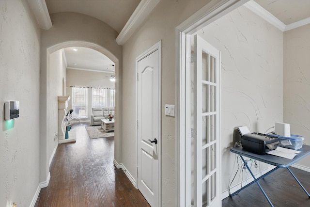 hall featuring hardwood / wood-style flooring, baseboards, arched walkways, and ornamental molding