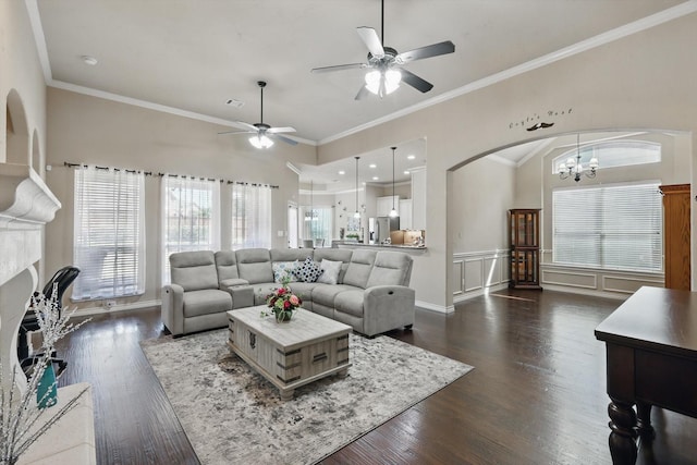 living area with a glass covered fireplace, dark wood-type flooring, visible vents, and ornamental molding