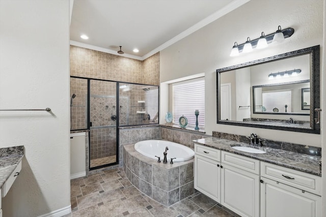 bathroom featuring a garden tub, a stall shower, ornamental molding, vanity, and a textured wall