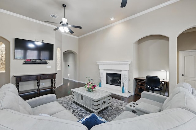 living room with visible vents, dark wood-type flooring, a ceiling fan, and a fireplace