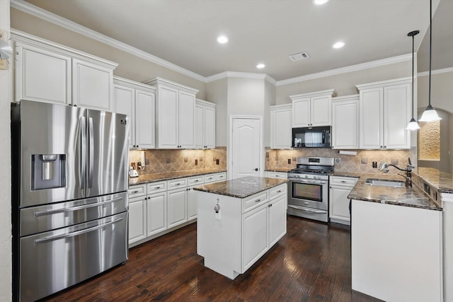 kitchen with dark wood-style floors, a kitchen island, a sink, appliances with stainless steel finishes, and white cabinetry