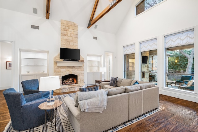 living room featuring visible vents, built in shelves, beam ceiling, dark wood-style floors, and a fireplace