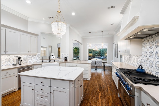 kitchen featuring stainless steel appliances, visible vents, a chandelier, and custom range hood