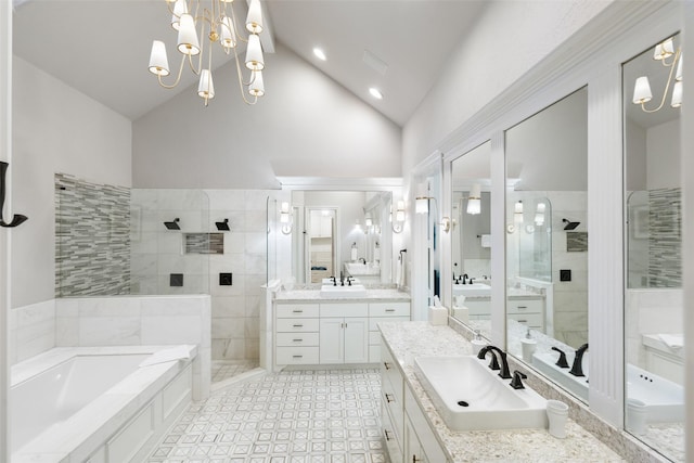 bathroom featuring a bath, two vanities, walk in shower, and a sink