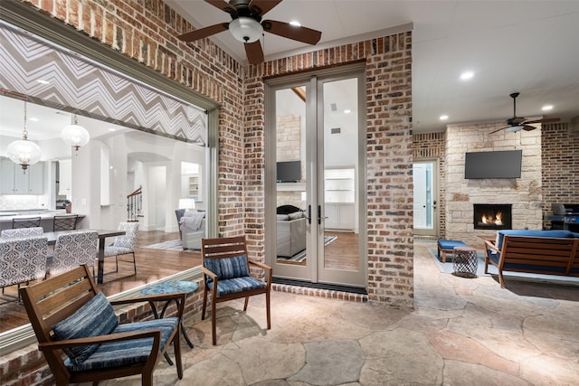 view of patio with outdoor dining space, a fireplace, french doors, and ceiling fan