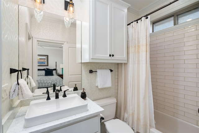 ensuite bathroom featuring connected bathroom, crown molding, toilet, shower / bath combination with curtain, and vanity