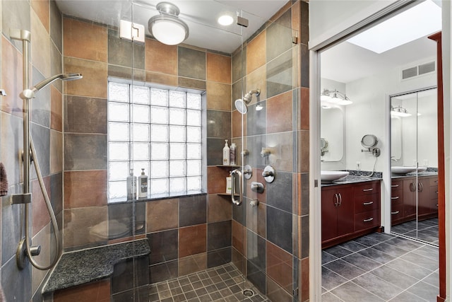 full bath featuring vanity, visible vents, and tiled shower