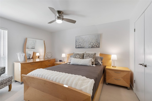 bedroom featuring light carpet and a ceiling fan