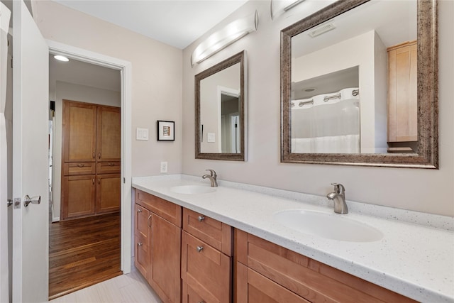 bathroom featuring double vanity, visible vents, and a sink