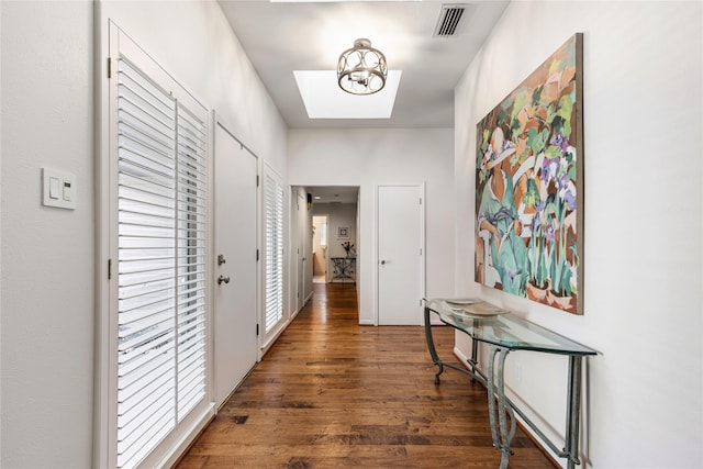 hall featuring visible vents, a notable chandelier, and wood finished floors