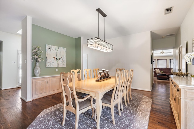 dining space featuring visible vents, baseboards, dark wood-style floors, and a ceiling fan