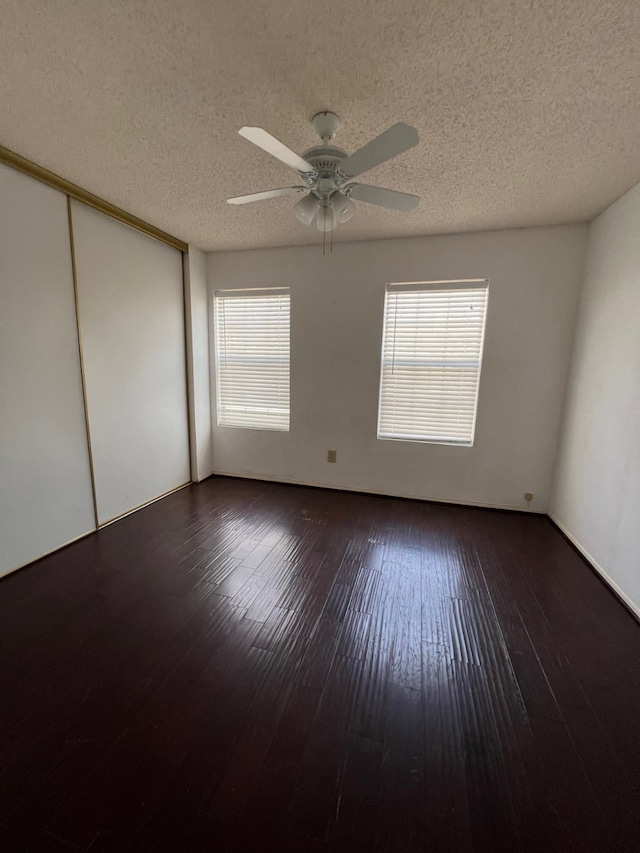 empty room with hardwood / wood-style flooring, plenty of natural light, a ceiling fan, and a textured ceiling