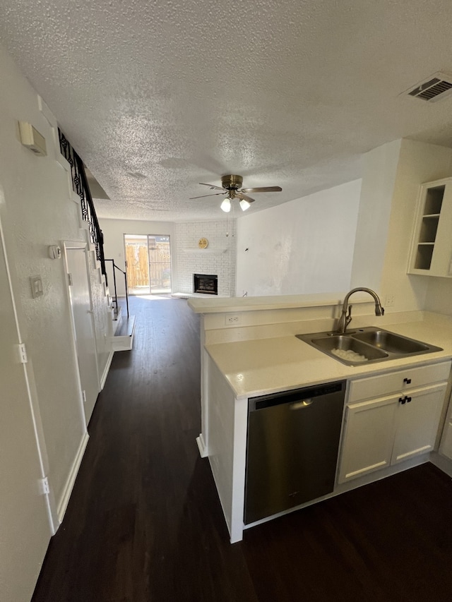 kitchen with visible vents, a peninsula, stainless steel dishwasher, a ceiling fan, and a sink