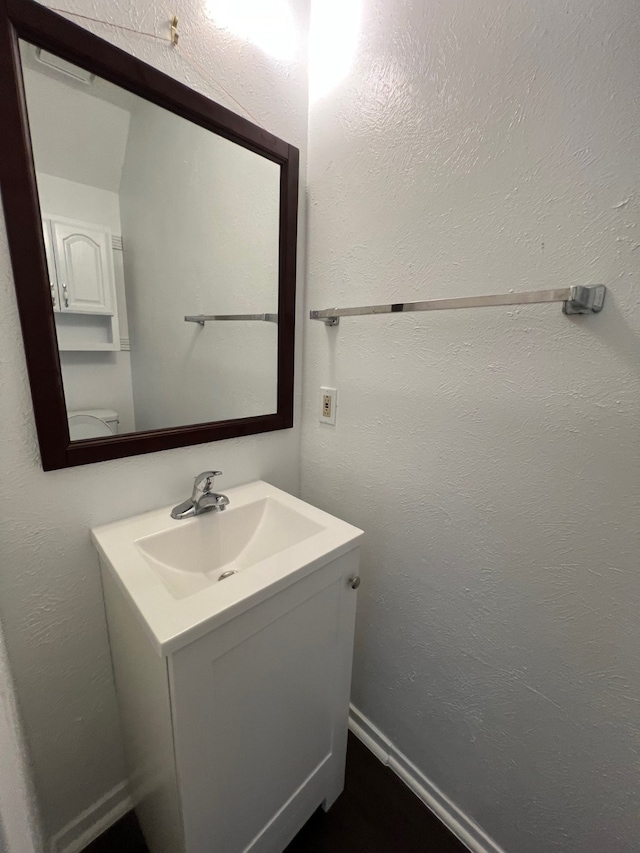 bathroom featuring vanity and a textured wall