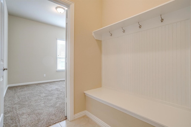 mudroom featuring light tile patterned floors, baseboards, and light carpet