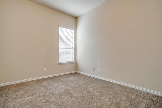 spare room with baseboards and carpet