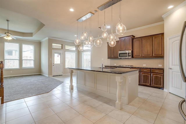 kitchen with open floor plan, backsplash, a ceiling fan, appliances with stainless steel finishes, and light tile patterned floors