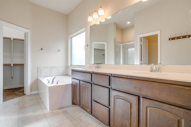 full bath featuring a garden tub, double vanity, a stall shower, tile patterned floors, and a sink