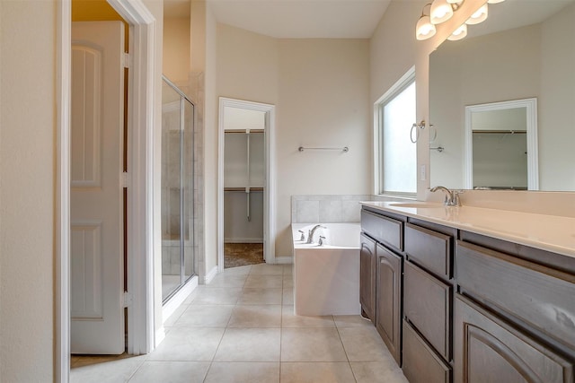 bathroom with vanity, a stall shower, a spacious closet, tile patterned floors, and a bath