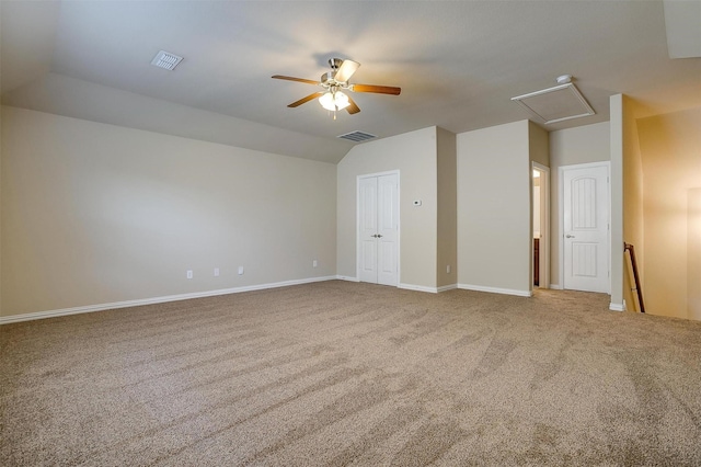 carpeted empty room featuring vaulted ceiling, visible vents, baseboards, and ceiling fan