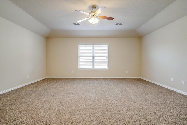 carpeted spare room featuring baseboards, a ceiling fan, and visible vents