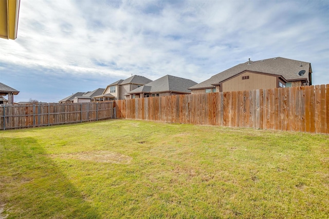 view of yard with a fenced backyard and a residential view