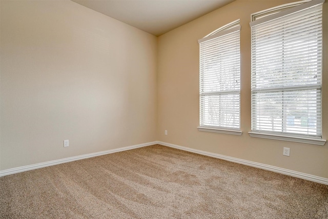 carpeted spare room with baseboards
