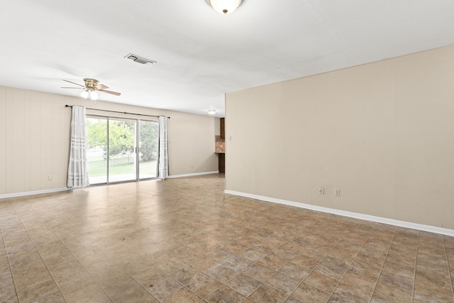 unfurnished room featuring baseboards, a ceiling fan, and visible vents