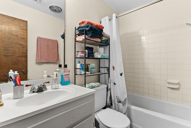 bathroom with shower / bath combination with curtain, a textured ceiling, toilet, and vanity