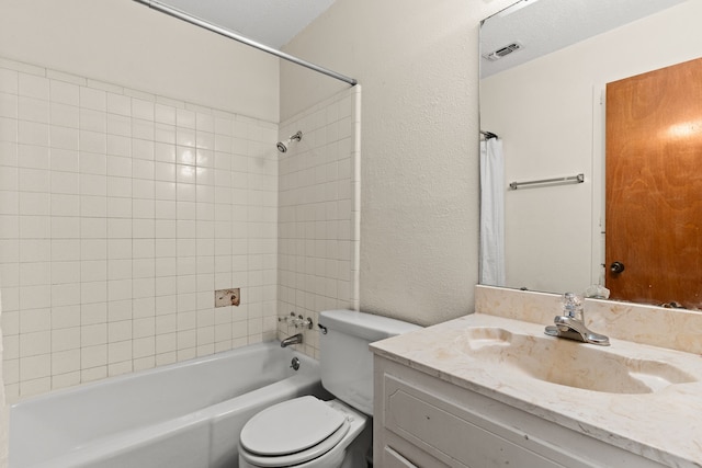 bathroom featuring vanity,  shower combination, a textured wall, toilet, and visible vents