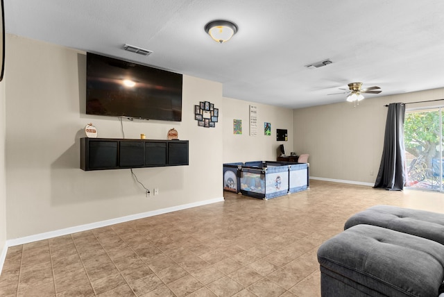 living area featuring visible vents, baseboards, and a ceiling fan