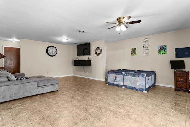 living room with visible vents, ceiling fan, and baseboards