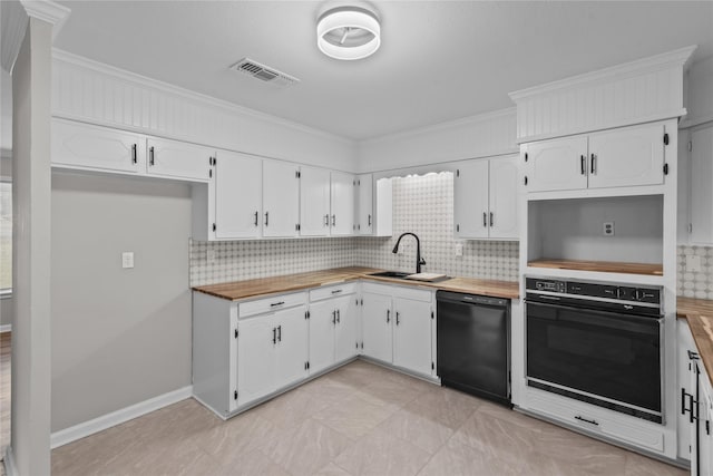 kitchen with visible vents, butcher block countertops, a sink, black appliances, and backsplash