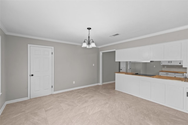 kitchen featuring an inviting chandelier, white cabinets, black electric cooktop, and visible vents