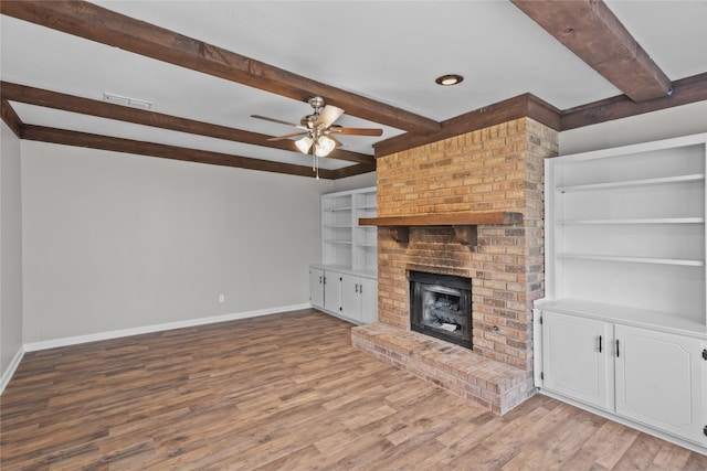 unfurnished living room featuring light wood finished floors, visible vents, ceiling fan, baseboards, and a fireplace