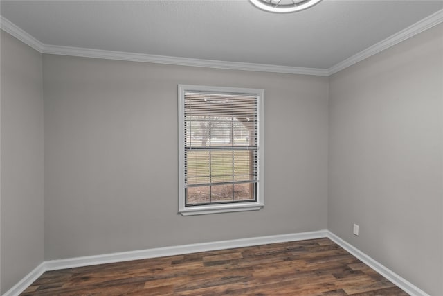 spare room featuring dark wood-type flooring, crown molding, and baseboards