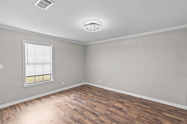 empty room with visible vents, crown molding, baseboards, and dark wood-style flooring