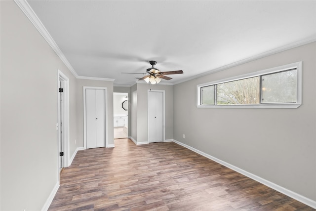 interior space with ceiling fan, baseboards, wood finished floors, and crown molding