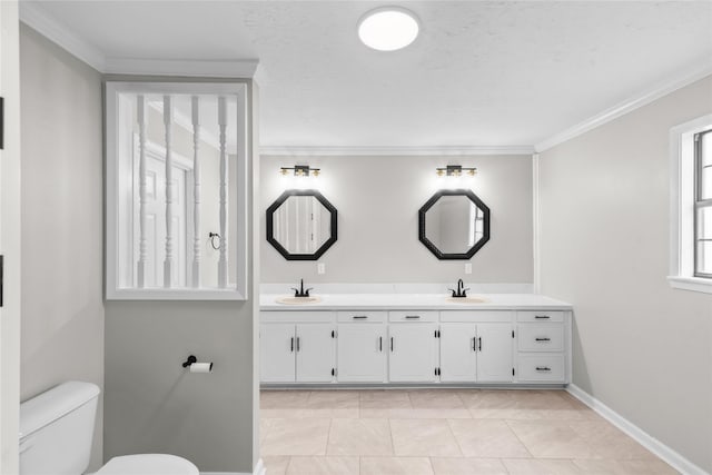 full bath featuring double vanity, ornamental molding, toilet, and a sink