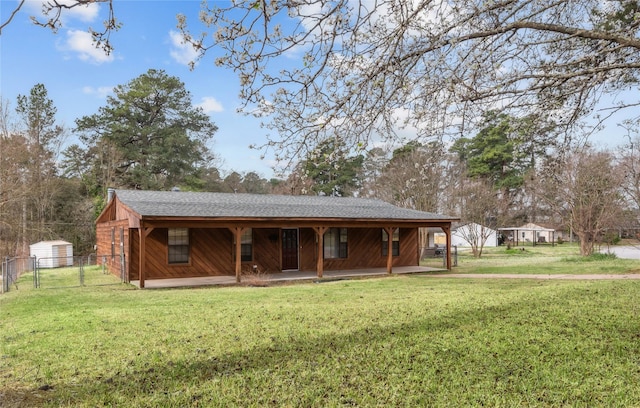 view of front facade featuring a gate, fence, roof with shingles, covered porch, and a front yard