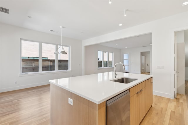 kitchen with visible vents, a sink, light countertops, dishwasher, and light wood-type flooring