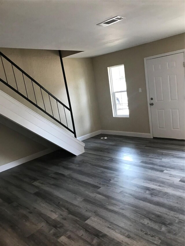 entryway with dark wood-style floors, visible vents, stairs, and baseboards