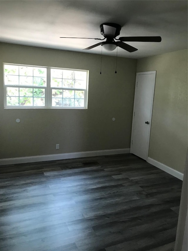 unfurnished room with dark wood finished floors and baseboards