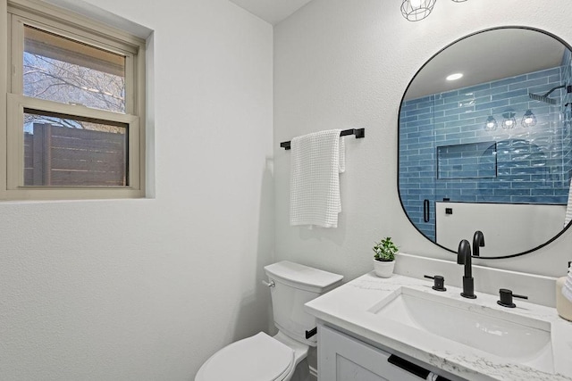 bathroom featuring vanity, toilet, and walk in shower