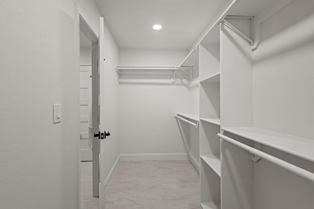 spacious closet with marble finish floor