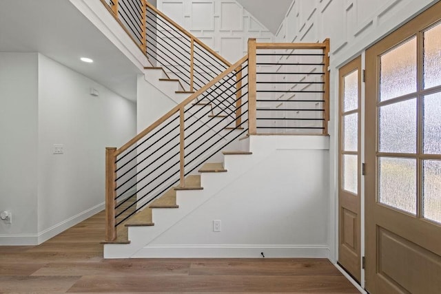 stairway featuring recessed lighting, baseboards, and wood finished floors