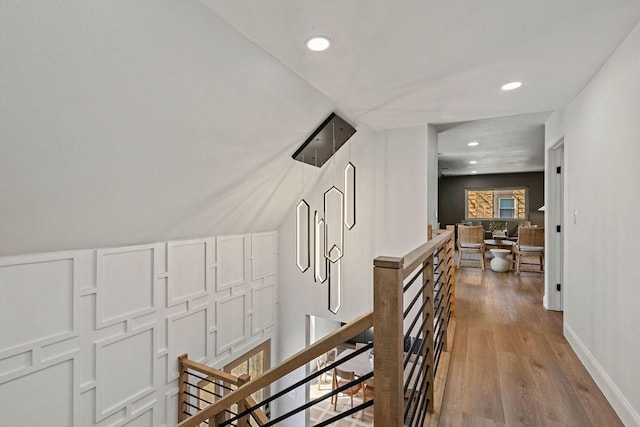 corridor with recessed lighting, baseboards, an upstairs landing, and wood finished floors