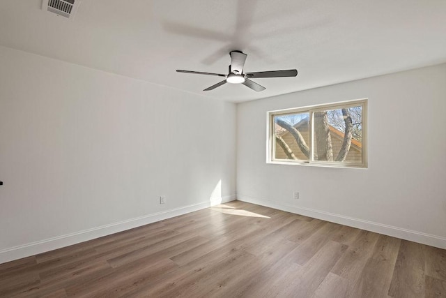 unfurnished room featuring visible vents, ceiling fan, baseboards, and wood finished floors