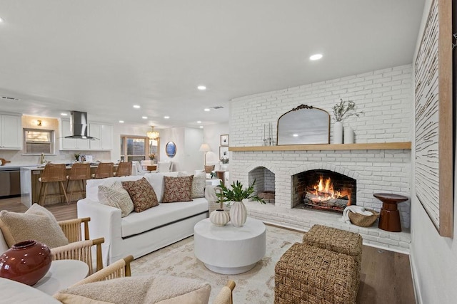 living area featuring recessed lighting, a fireplace, and light wood-style floors