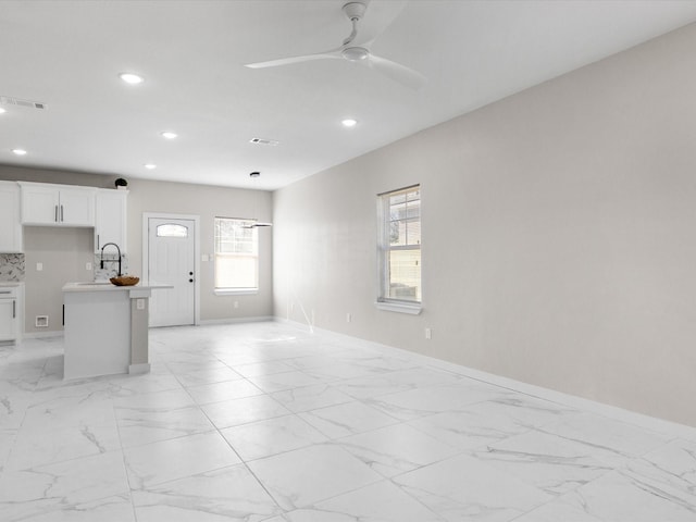 unfurnished living room with recessed lighting, visible vents, marble finish floor, and baseboards